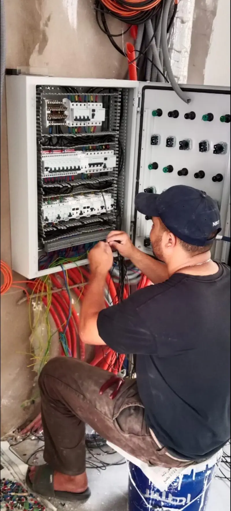 Électricien câblant un tableau électrique en cours d'installation